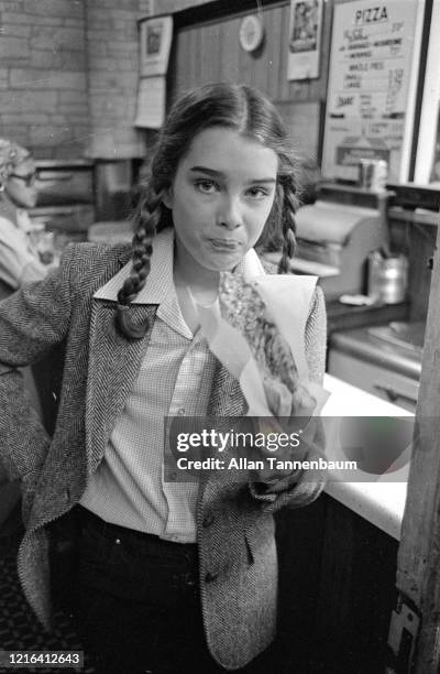 Portrait of American model and actress Brooke Shields as she eats a slice of pizza, New York, New York, April 7, 1978. At the time, she was filming...