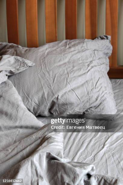 morning empty messy bed gray bed linen, bedclothes. sheet, blanket, pillows and wooden headboard. - satin pillowcase stock pictures, royalty-free photos & images
