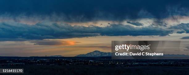 pikes peak as seen from denver, at sunset with lenticular clouds - aurora stock-fotos und bilder