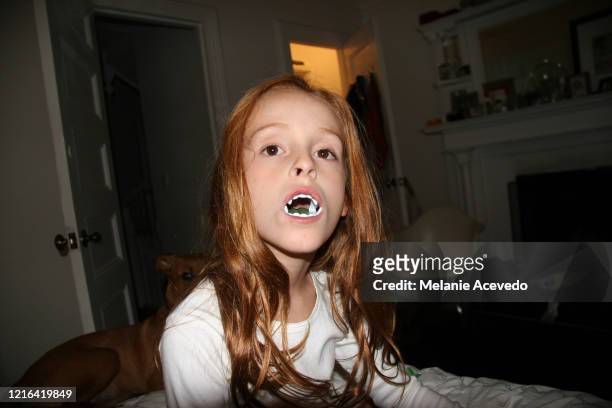 red headed long straight hair young girl wearing face plastic teeth halloween eyes open looking directly at camera close up - flash eyelashes stock pictures, royalty-free photos & images