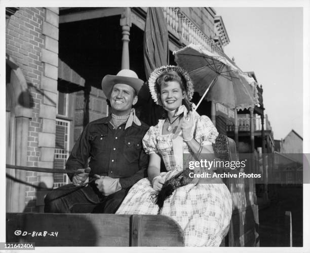 Gene Autry and Gail Davis sharing a carriage ride in a scene from the film 'Goldtown Ghost Riders', 1953.