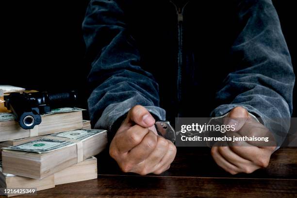 man with his hands handcuffed in criminal concept - cuff bracelet photos et images de collection