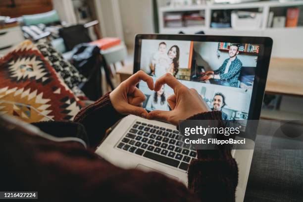 junge frau mit einem laptop, um mit ihren freunden und eltern während der quarantäne zu verbinden - millennial generation stock-fotos und bilder