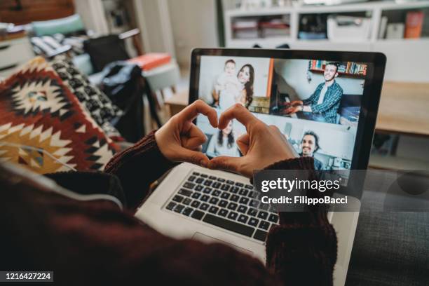 jonge vrouw die laptop gebruikt om met haar vrienden en ouders tijdens quarantaine te verbinden - love connection family stockfoto's en -beelden