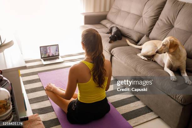 woman practicing yoga in video conference - online yoga stock pictures, royalty-free photos & images