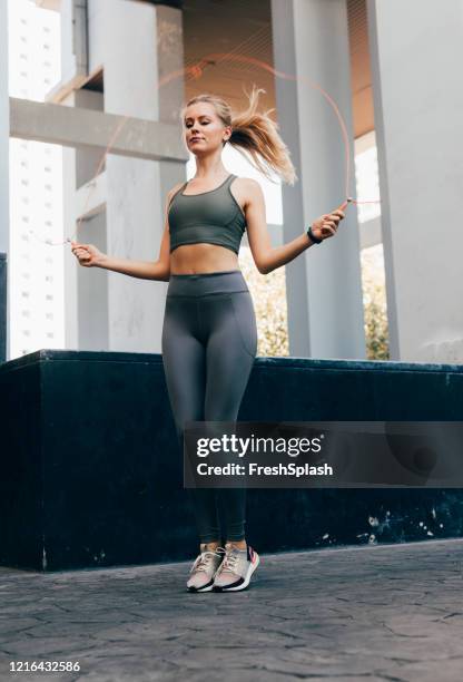 cardio motion: vacker blond kvinna i fitness tights och top jumping repet - jump rope bildbanksfoton och bilder