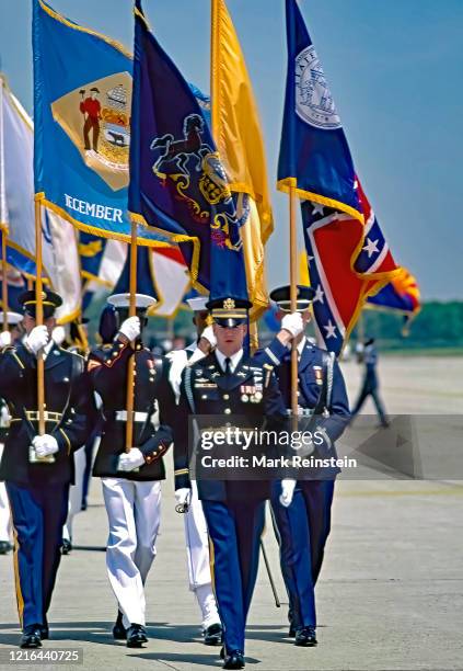 Members of the combined forces color guard carrying various states flags march down the apron of the runway at Andrews Air Force Base during the...