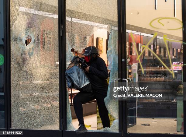 People are seen looting stores at the Grove shopping center in the Fairfax District of Los Angeles on May 30, 2020 following a protest against the...