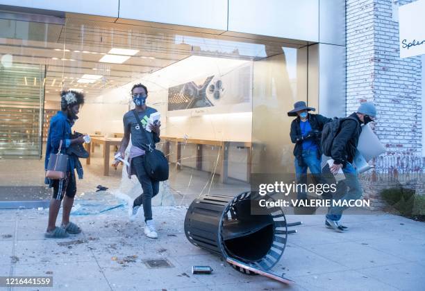 People are seen looting the Apple store at the Grove shopping center in the Fairfax District of Los Angeles on May 30, 2020 following a protest...