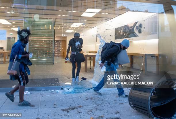People are seen looting the Apple store at the Grove shopping center in the Fairfax District of Los Angeles on May 30, 2020 following a protest...