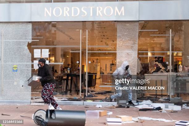 People are seen looting stores at the Grove shopping center in the Fairfax District of Los Angeles on May 30, 2020 following a protest against the...