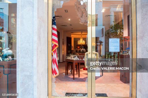 Store window is left broken after people looted it in the Grove shopping center in the Fairfax District of Los Angeles on May 30, 2020 following a...