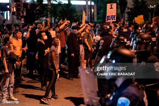 Demonstrators confront police officers on May 30, 2020 in Washington DC, during a protest over the death of George Floyd, an unarmed black man, who...