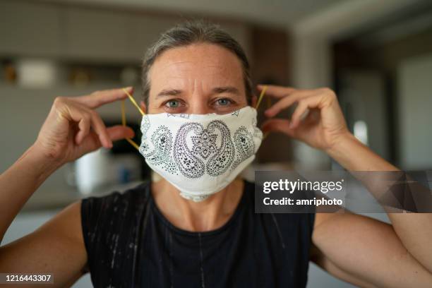 woman with homemade mouth nose mask looking at camera - austria covid stock pictures, royalty-free photos & images