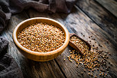 Dietary fiber: wholegrain buckwheat in a wooden bowl on rustic kitchen table