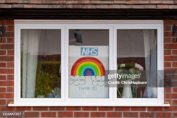 rainbow drawings in window of house during covid19 in uk. - nhs rainbow stock pictures, royalty-free photos & images