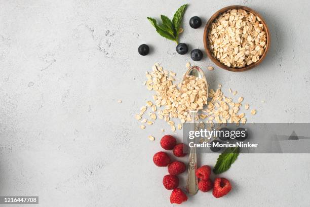 bacche biologiche, farina d'avena e foglie di minte in composizione contemporanea - avena cereali da colazione foto e immagini stock