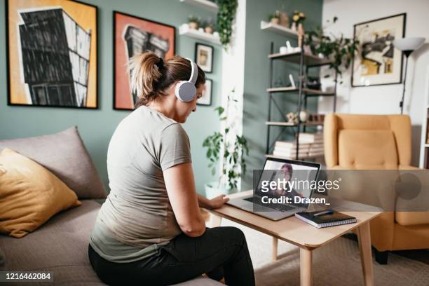 Young woman teleconferencing with friend on laptop