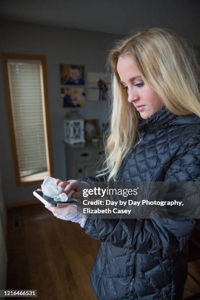 girl wiping mobile phone screen - lakeville minnesota stock pictures, royalty-free photos & images