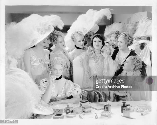 Virginia Bruce sits by pouting as Luise Rainer gets the attention of their fellow performers in a scene from the film 'The Great Ziegfeld', 1936.