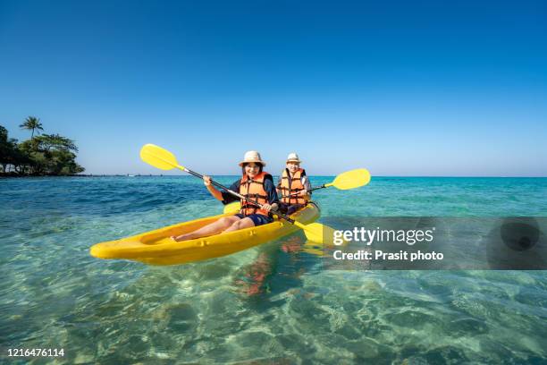 happy asian couple to play kayak in the blue lagoon ocean sea in koh kood island in trat, thailand.  water travel adventure tourism destination place asia, summer holiday vacation trip - happy couple exotic stock pictures, royalty-free photos & images