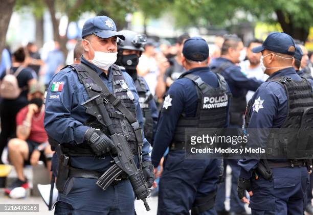 Police officer with a face mask stand guard during the operation to temporarily close the facilities of the Plaza de la Tecnología de Monterrey, to...
