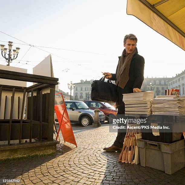 businessman looks at magazines on stand, city - krantenkiosk stockfoto's en -beelden