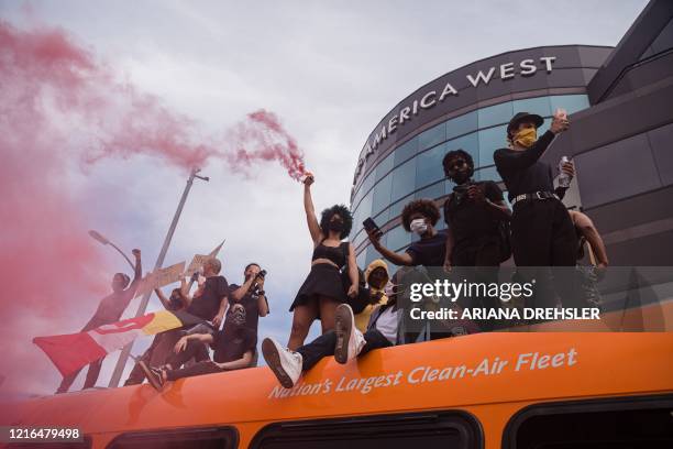 Demonstrators stand on a bus in the Fairfax district of Los Angeles on May 30, 2020 during a protest against the death of George Floyd, an unarmed...