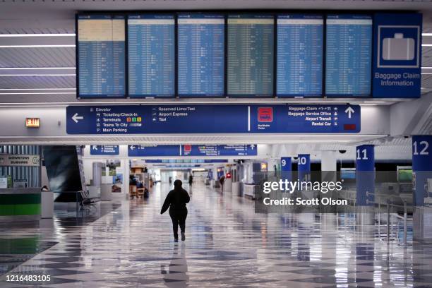 Worker walks through a baggage claim area at a nearly-empty O'Hare International Airport on April 2, 2020 in Chicago, Illinois. The airport, which...