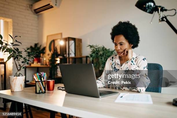 hispanische geschäftsfrau arbeitet von zu hause aus - mature reading computer stock-fotos und bilder