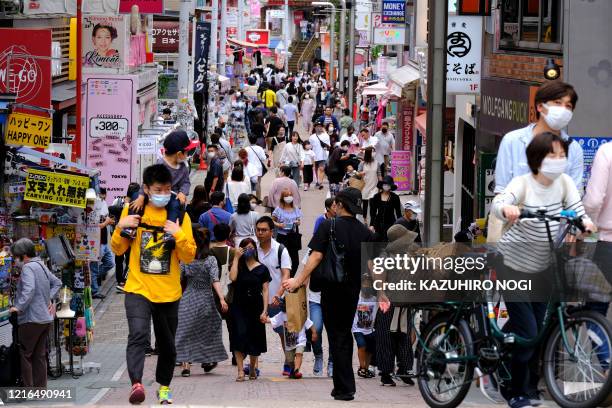People walk on Takeshita street in Tokyo's fashion district Harajuku on May 31 during the first weekend after the government lifted a state of...