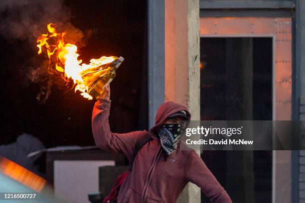 Man throws a Molotov cocktail on Melrose Avenue in the Fairfax District during demonstrations following the death of George Floyd on May 30, 2020 in...