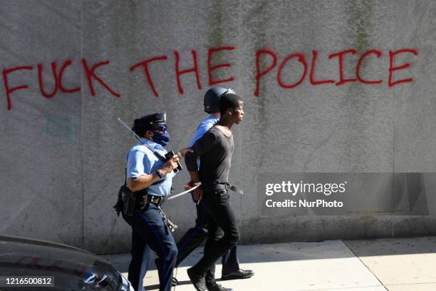 Police handle an arrested African-American male as protesters clash with police near City Hall, in Philadelphia, PA on May 30, 2020. Cities around...