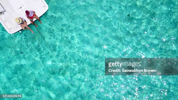 top view of happy young couple fishing on the luxury boat in ocean, copy space - maldives sport stock pictures, royalty-free photos & images