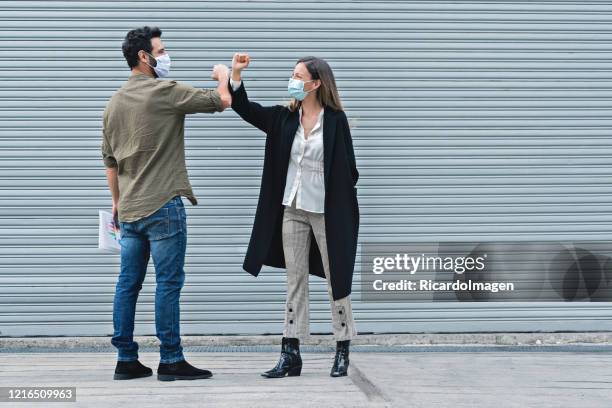 co-workers waving with the elbow taking care of the contagion of covid-19 - covid greeting stock pictures, royalty-free photos & images