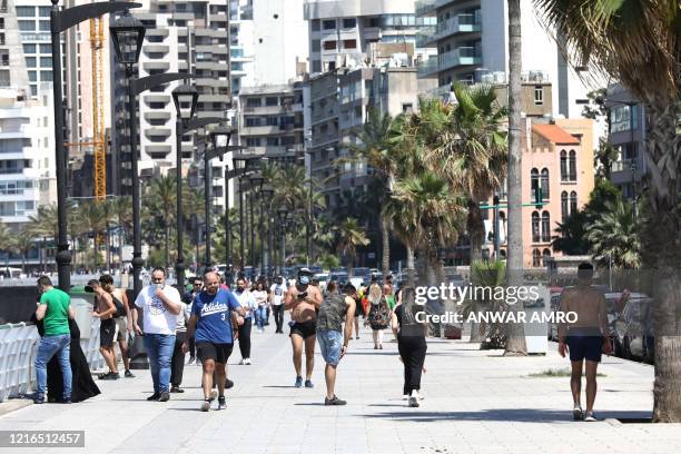 Residents of the Lebanese capital Beirut stroll along the seaside corniche, despite the lingering threat of the novel coronavirus, on May 31, 2020.