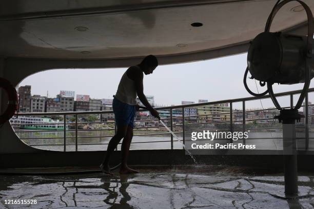 Workers are washing a boat at Sadarghat Launch Terminal as government decided to open all kind of public transportation.