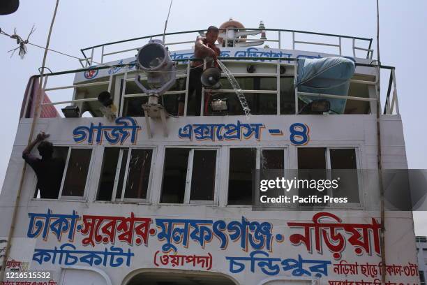 Workers are washing a boat at Sadarghat Launch Terminal as government decided to open all kind of public transportation.