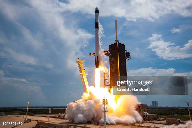 In this SpaceX handout image, a Falcon 9 rocket carrying the company's Crew Dragon spacecraft launches on the Demo-2 mission to the International...