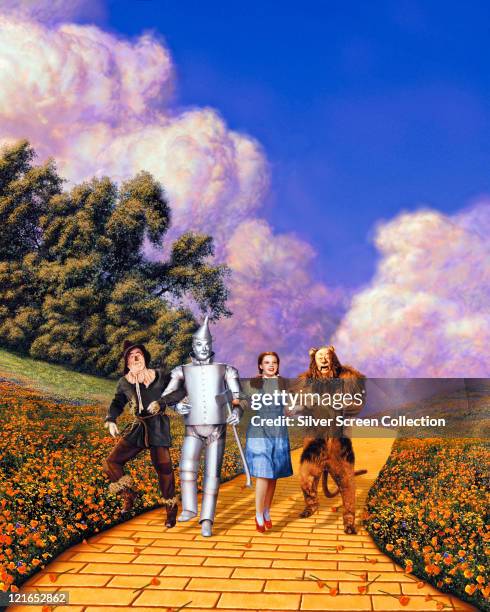 Actors Ray Bolger , Jack Haley , Judy Garland and Bert Lahr in costume on the yellow brick road in a scene from the film 'The Wizard of Oz', 1939.