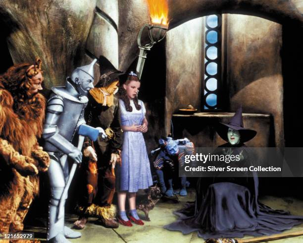 Actors Bert Lahr , Jack Haley , Ray Bolger , Judy Garland and Margaret Hamilton in costume during a scene from the film 'The Wizard of Oz', 1939.