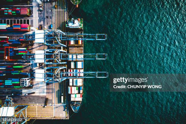 container cargo freight ship with working crane bridge discharge at container terminal, drone view container ship at deep sea port. - container yard stock pictures, royalty-free photos & images