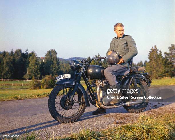 Steve McQueen , US actor, wearing a German military uniform, sitting astride a motorcycle in a publicity still issued for the film, 'The Great...