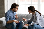 Stressed young married family couple arguing, blaming each other.