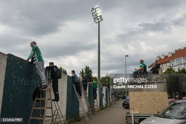 Bohemians' supporters watch the Czech First League football match between Bohemians 1905 and SK Dynamo Ceske Budejovice behind a wall amid the new...