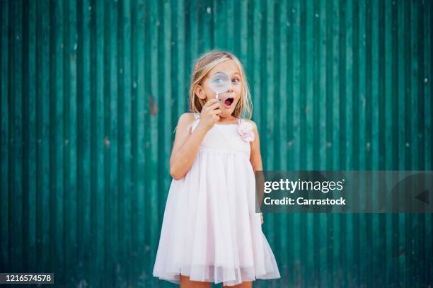 little blond girl with blue eyes and magnifying glass - child magnifying glass stock-fotos und bilder