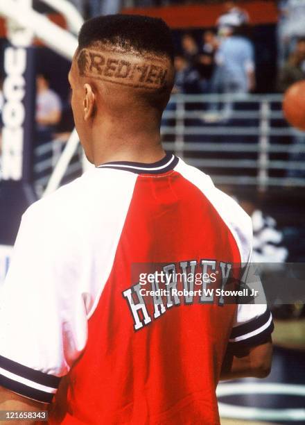 Greg 'Boo' Harvey, point guard for the St. Johns University men's basketball team, sports the team nickname 'Redmen' emblazoned in his hairdo, during...