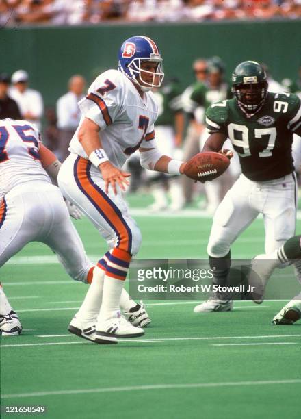 Denver Broncos quarterback John Elway directs the offense during a game against the New York Jets, Piscataway, NJ, 1994. Marvin Washington, a...