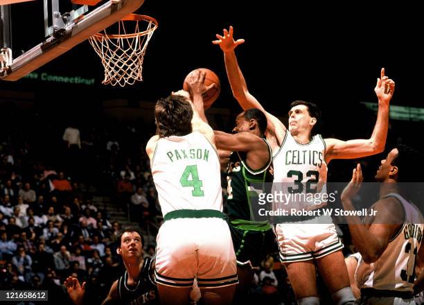 Boston Celtic forward Kevin McHale, #32, and teammate Jim Paxson, #4, clog the middle while playing defense against a player from the Milwaukee...