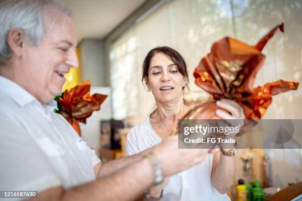 senior couple buying easter egg in a store - convenience chocolate stock pictures, royalty-free photos & images